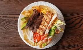 A tostada salad served in a crisp tortilla shell with avocado and cheese
