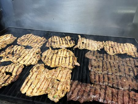 Chicken and steak on the flat-top grill, marked from the bars